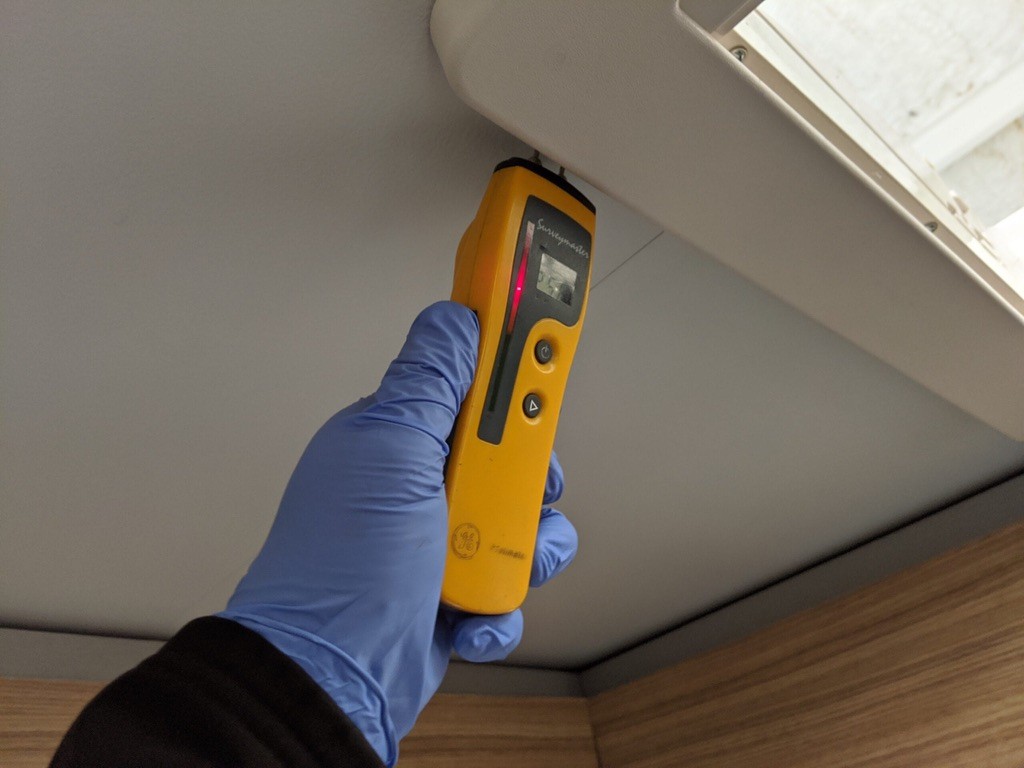 A moisture meter checking for damp inside a campervan