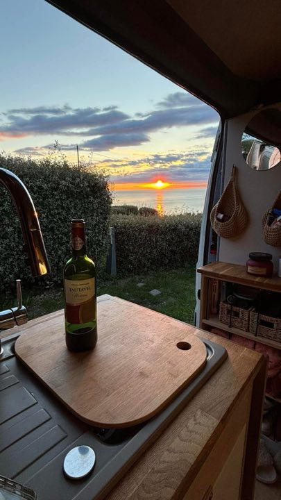 A campervan touring beside a dramatic coastline
